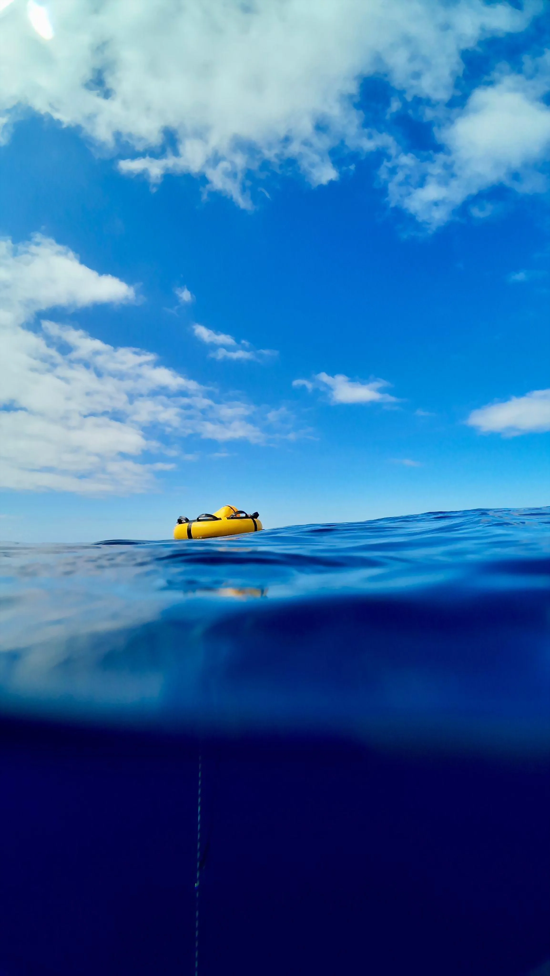 A freediving buoy and descent line at the surface in open blue water off Madeira